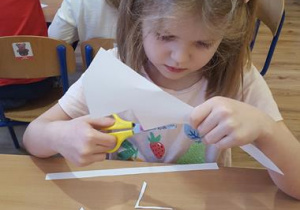 Dziewczynka wycina koronę z papieru